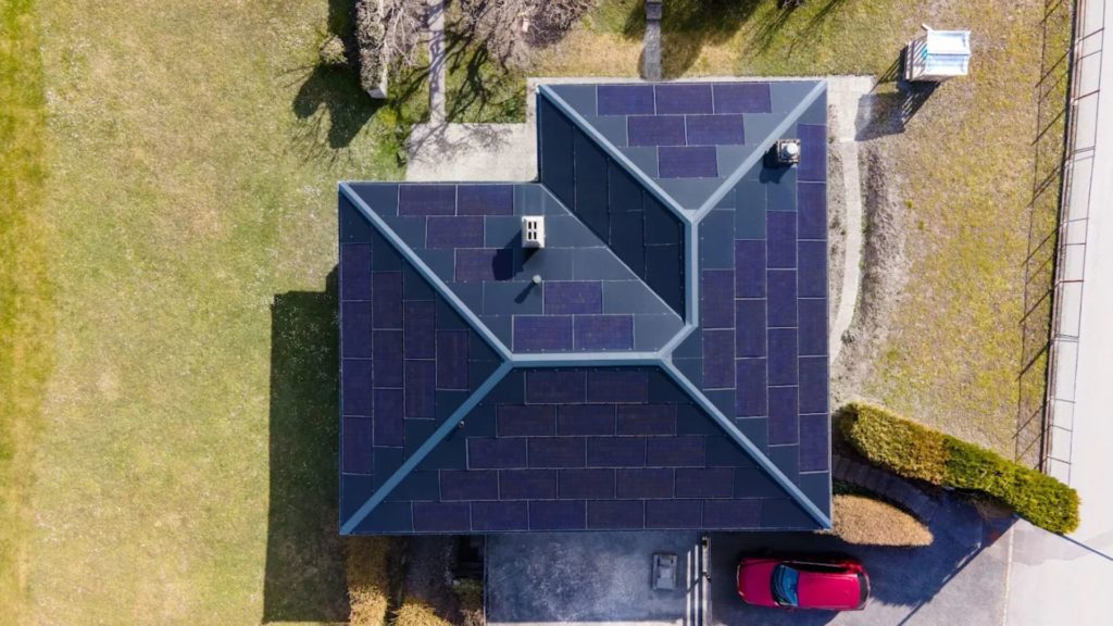 Toiture équipée de panneaux solaires intégrés Megasol, installation esthétique réalisée par Monelec dans la région du Chablais - Valais.